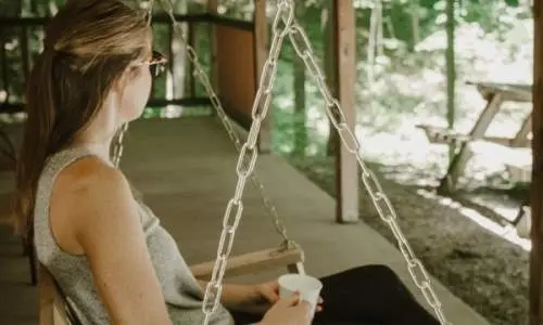 キャビンデッキの吊り椅子に座る女性