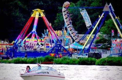 川とボートを背景にした祭りの乗り物