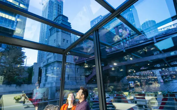 オデッセイ・クルーズのガラス張りの屋上から眺めるカップル