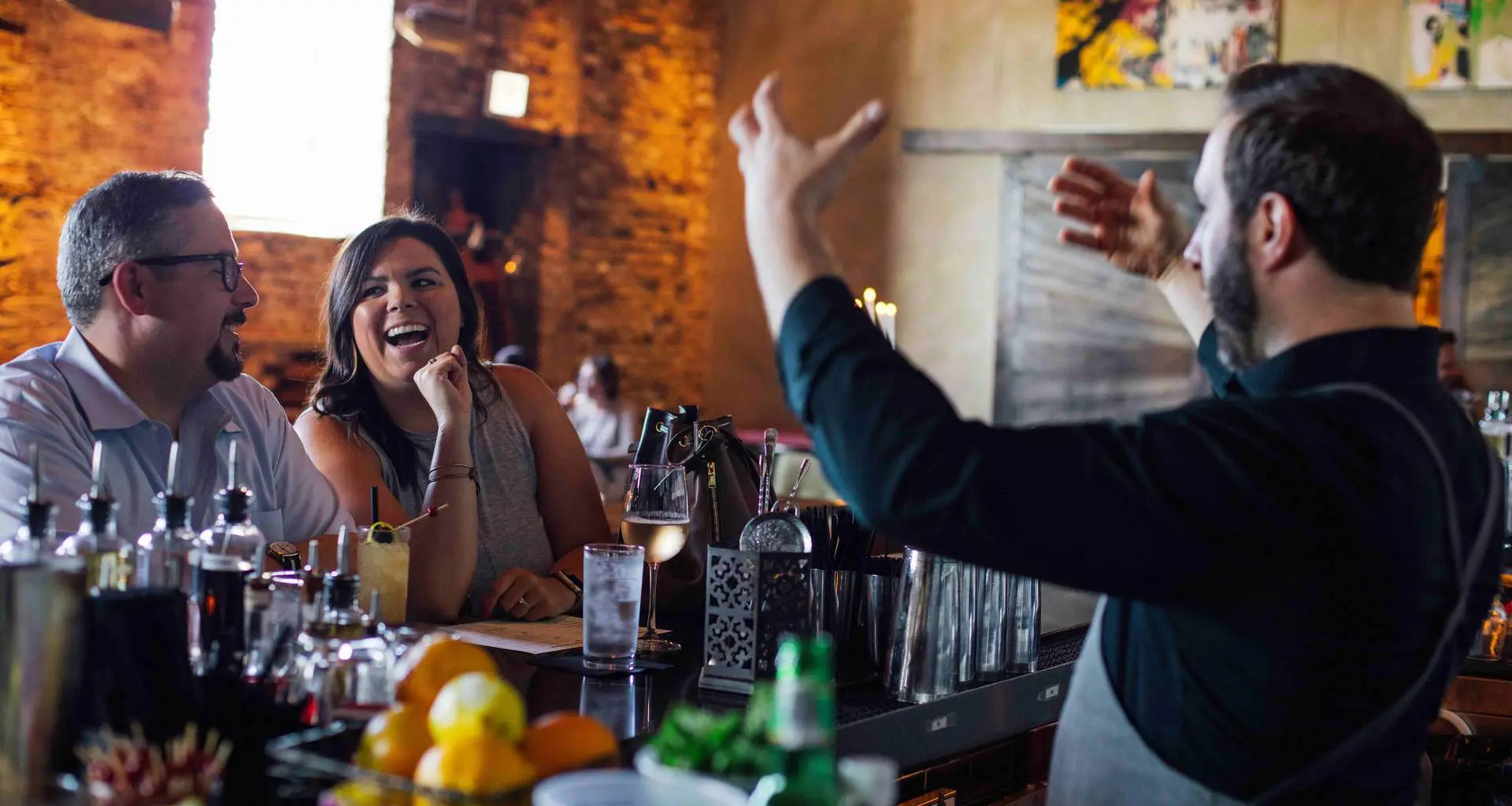 客をもてなすバーテンダー。 