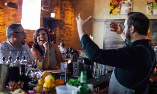 客をもてなすバーテンダー。 