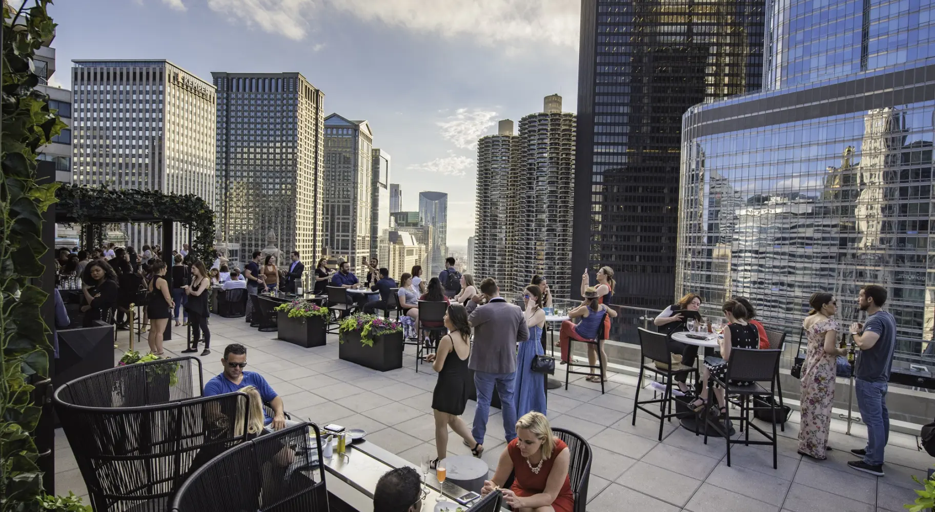 高層ビルが立ち並ぶルーフトップバーに集まった人々