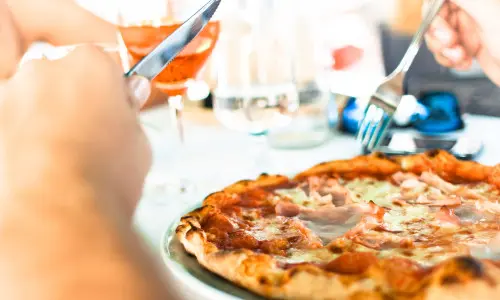 ナイフとフォークでピザを食べる人