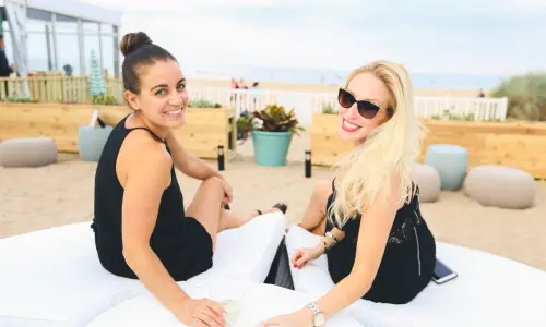 ビーチのラウンジで飲み物を楽しむ2人の女性