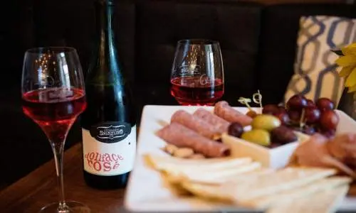 テーブルの上に置かれたチーズの大皿と2、3杯のワイングラス