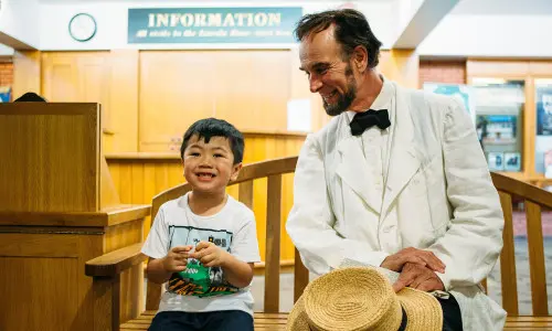 部屋の中で椅子に座る少年と男性