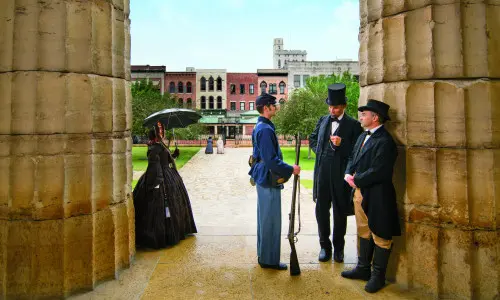 年配の服装をした人々が立っている