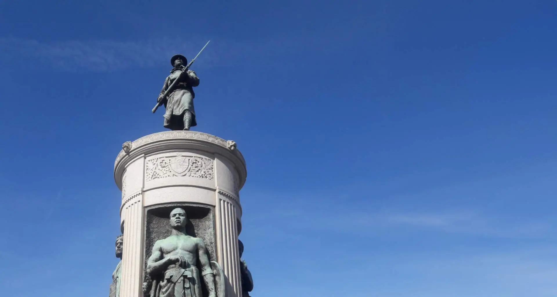 花崗岩の台座には、第一次世界大戦時の「ドーボーイ」兵士の風化したブロンズ像が置かれている。