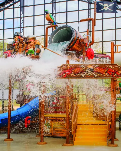 屋内ウォーターパークで海賊をテーマにしたプレイタワーに水をかけるダンプバケツ