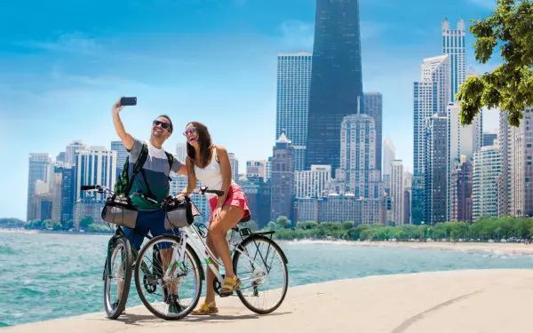 湖畔の小道を自転車で走り、記念写真を撮るカップル