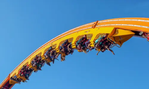 空中でジェットコースターに乗る人々。 