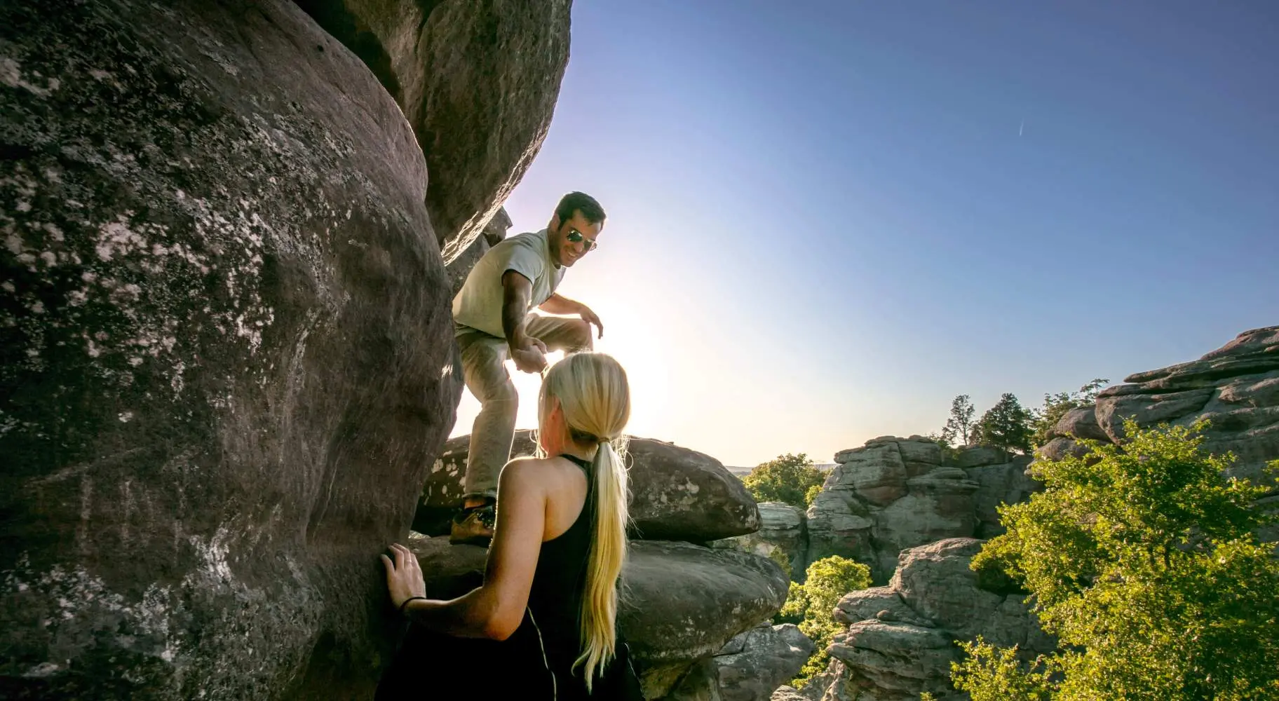 大きな岩をよじ登る二人